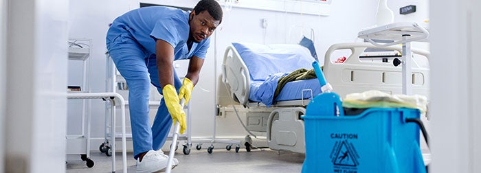 Environmental Services Technician cleaning the floors of a patients hospital room