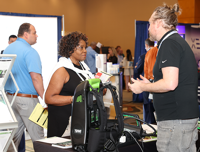 Exchange Summit attendee talking to exhibitor