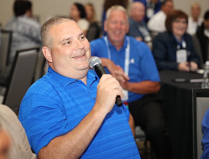 Exchange Summit attendee asking question with microphone during session